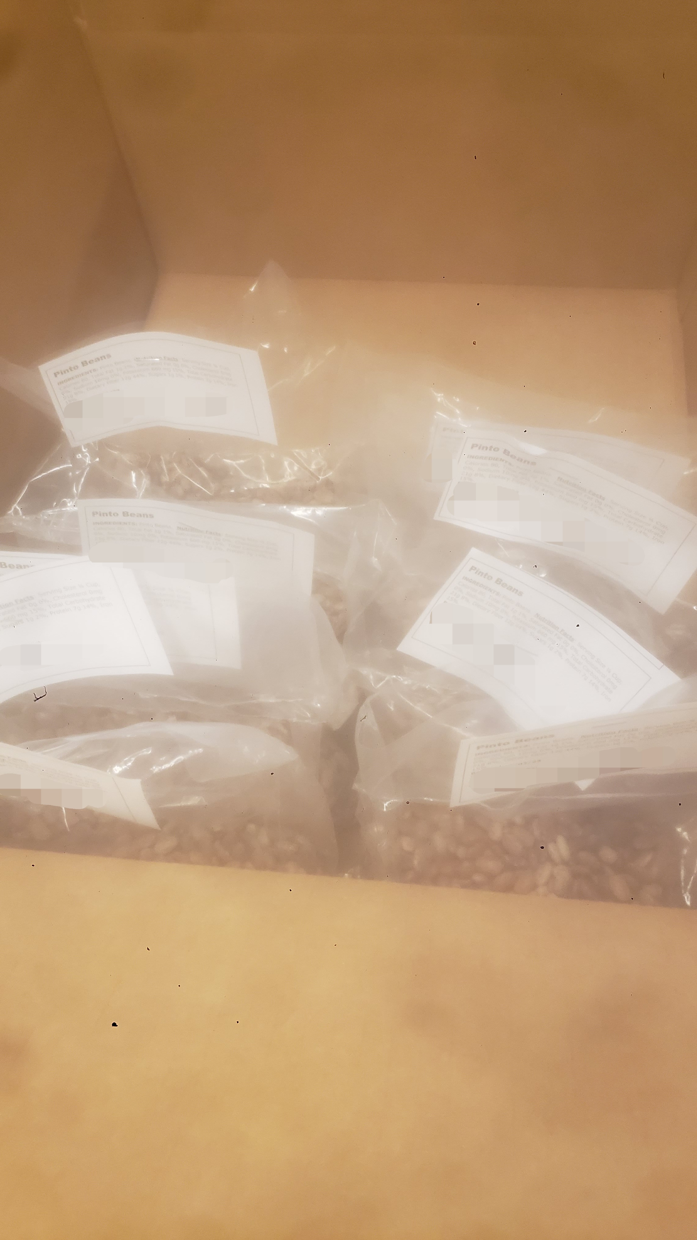 Stack of bagged pinto beans in a box.